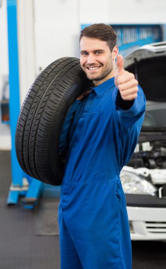 Mechanic holding a tire wheel at the repair garage